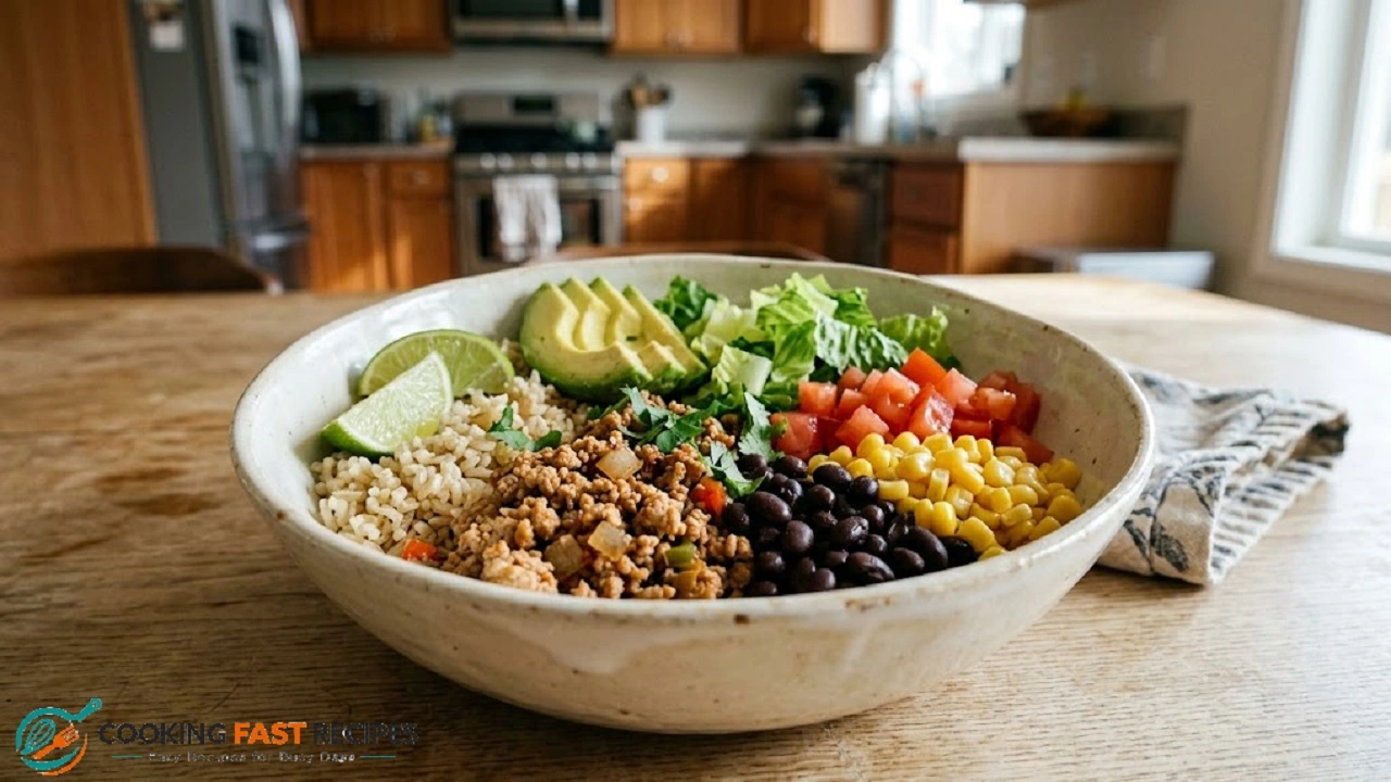 Turkey taco bowl with brown rice, black beans, corn, lettuce, tomatoes, and avocado